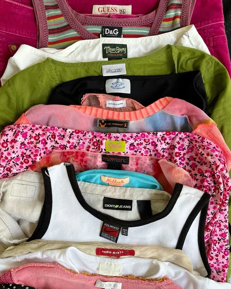 A stack of multiple colorful women's tank tops and T-shirts folded on top of each other.