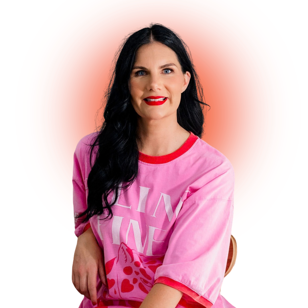 A woman with long black hair, red lipstick, wearing a pink shirt with a heart and giraffe design, sitting with her arm resting on her lap against an orange circular gradient background.