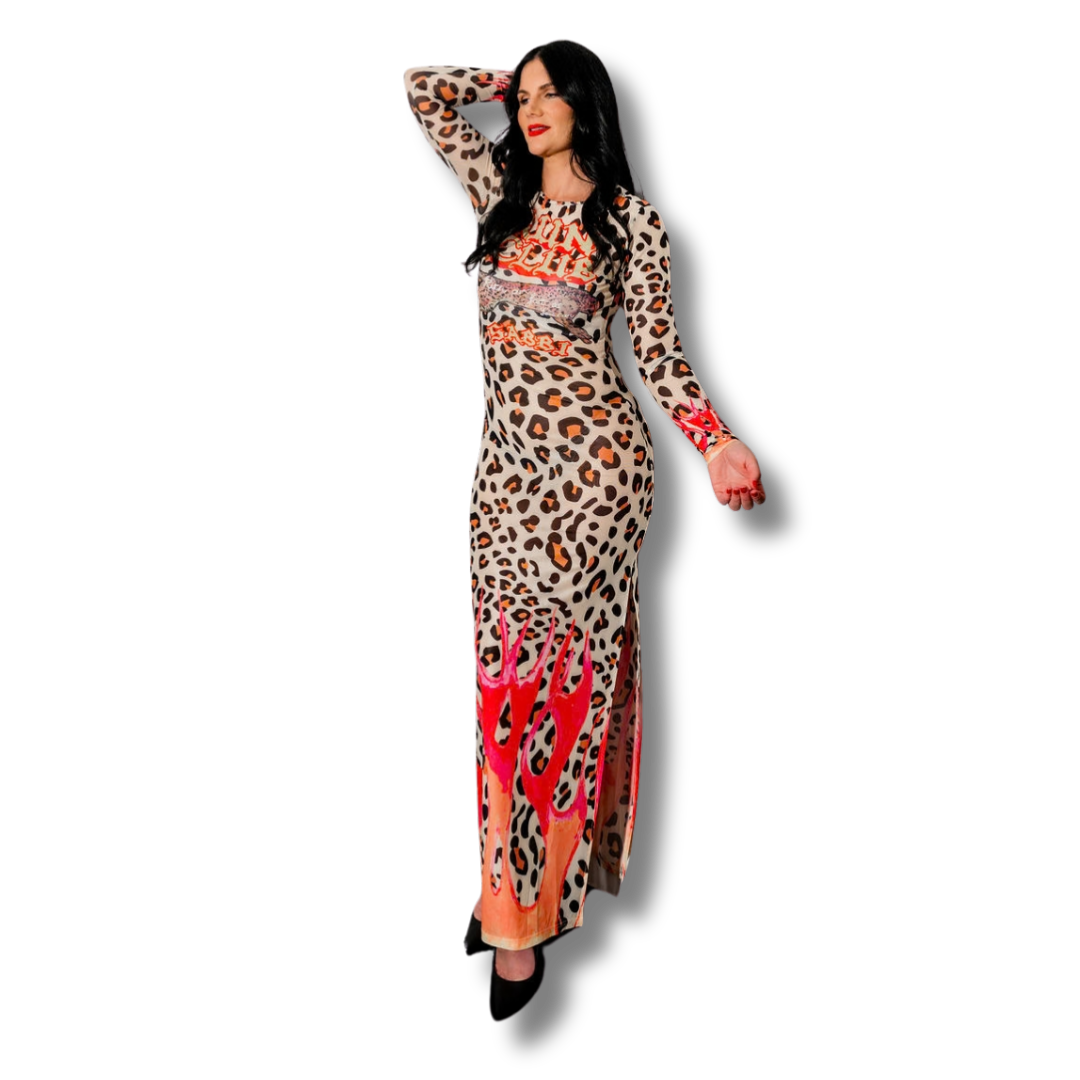 Woman with black hair wearing a leopard print dress with red accents, standing with one arm raised, against a black background.