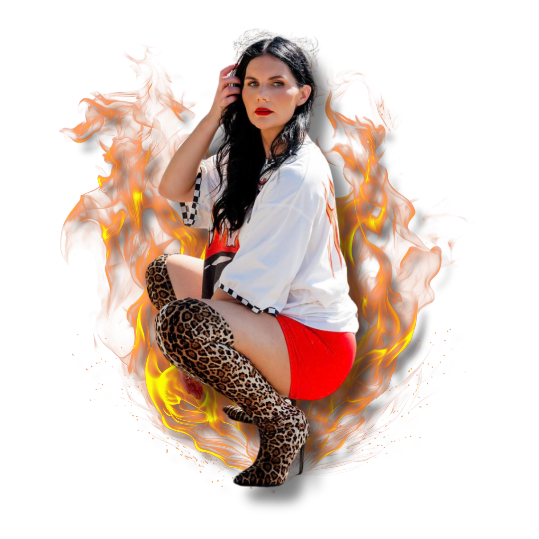 A woman with dark hair and red lipstick sitting with one knee up, wearing a white shirt, red shorts, and leopard print thigh-high boots, surrounded by flames.