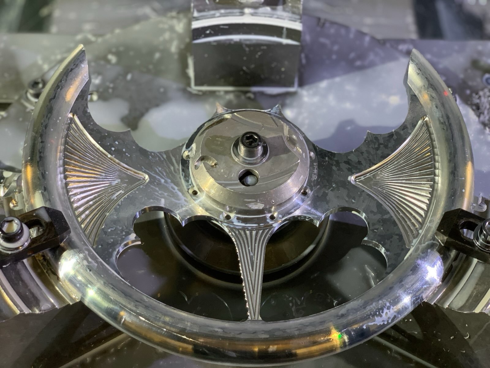 Close-up of a metal mechanical part, possibly an engine or machinery component, with intricate details and a reflective surface.