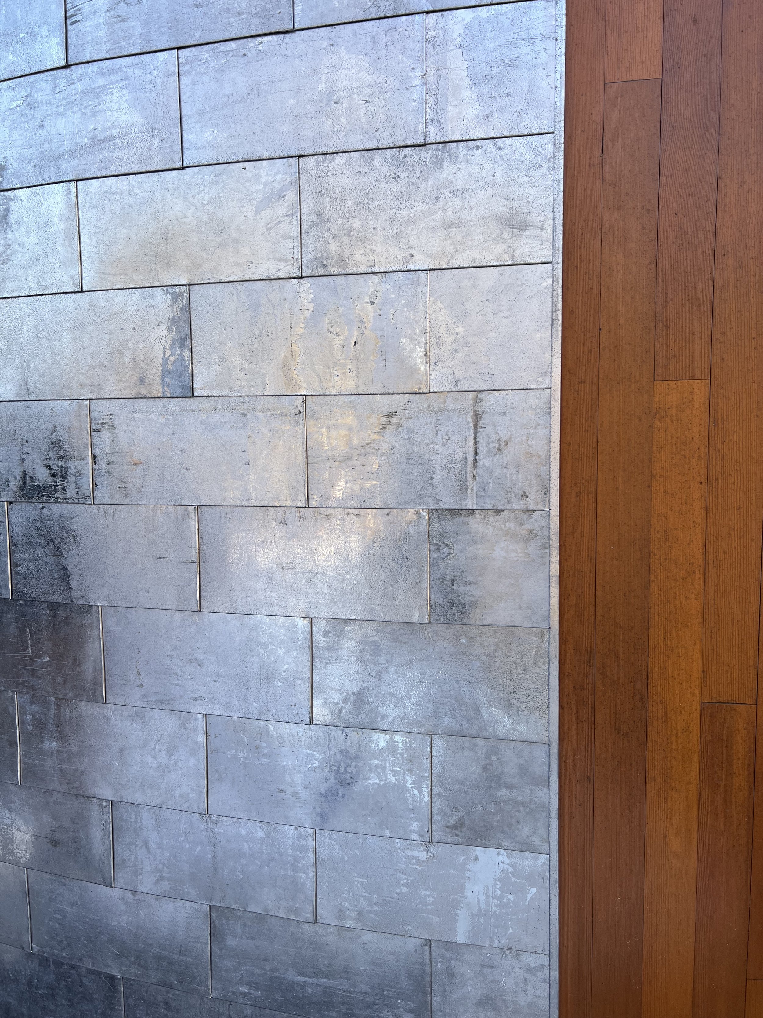 This image shows a combination of light gray stone tiles and reddish-brown wooden planks arranged horizontally.