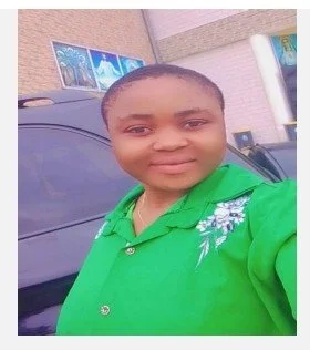 Young boy in a bright green shirt taking a selfie outside with a building and car in the background.