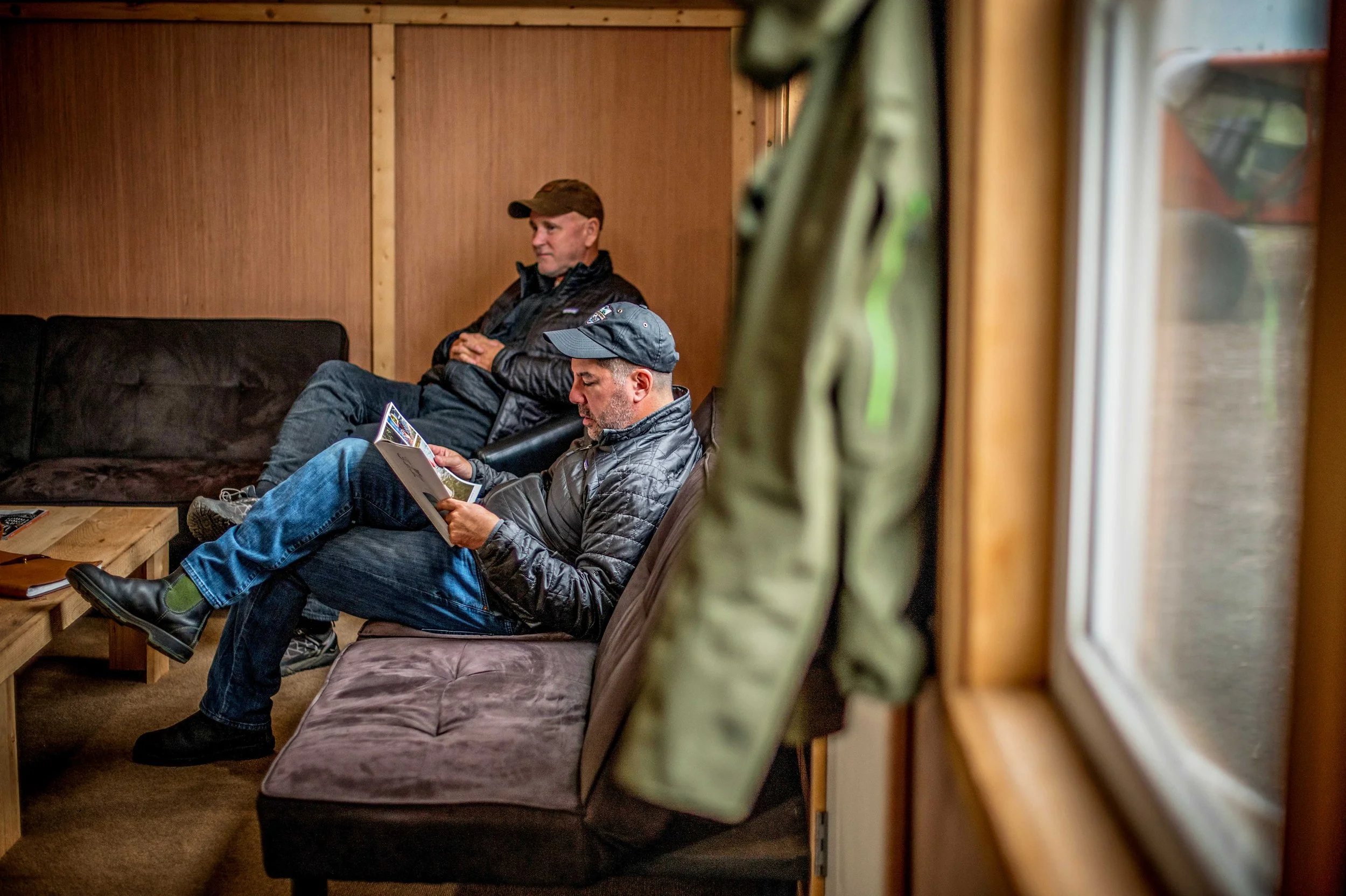 Two guests relaxing in the main lodge at Lava Creek Lodge."