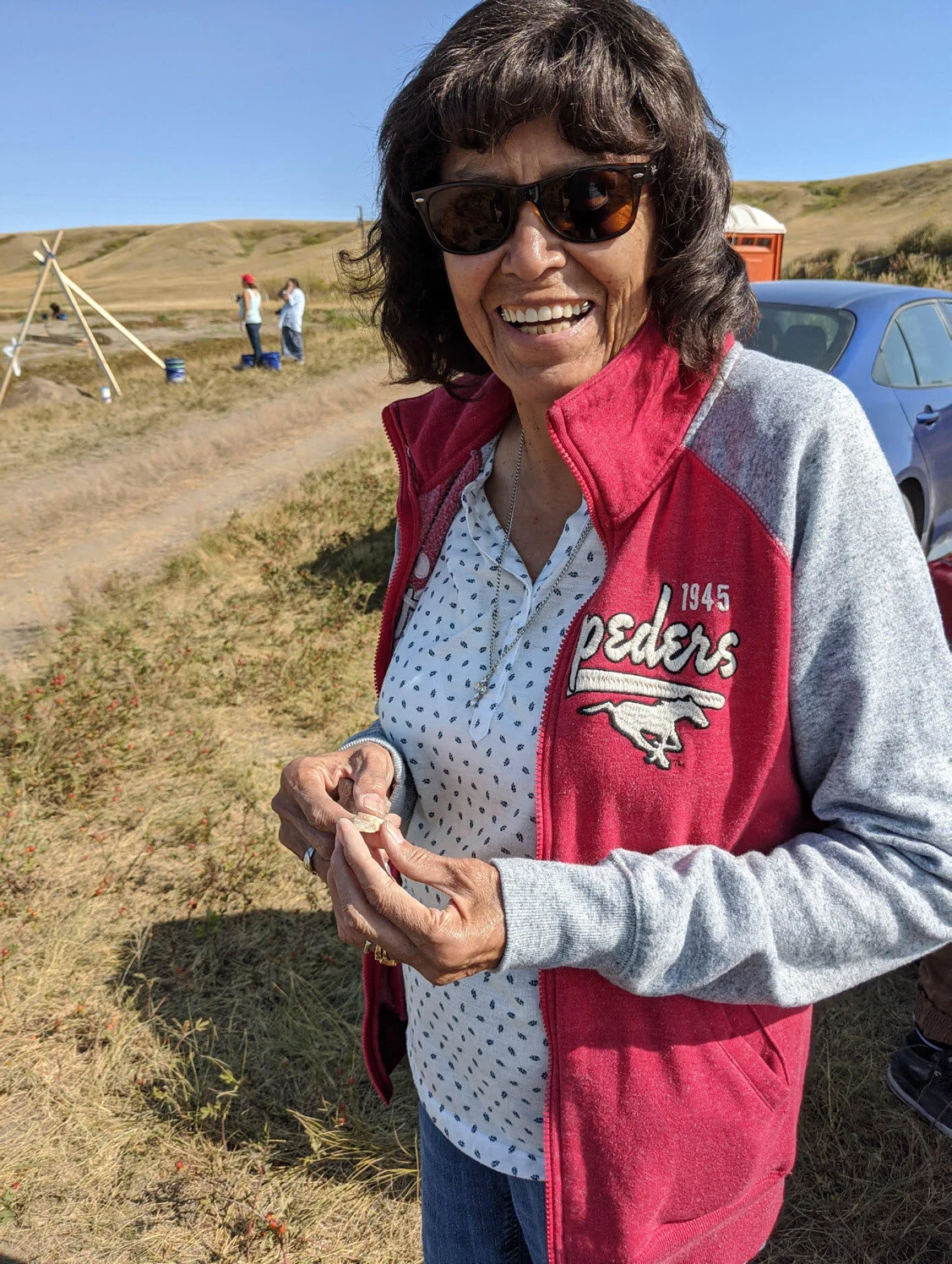 Elder Gwen Bear Cheif Examines Projectile Point. Courtesy of University of Calgary / Old Sun Community College.