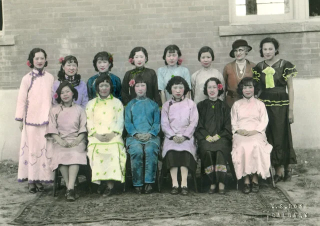 This hand-coloured black and white photo shows young women dressed in their finest clothing as volunteer servers for the ‘Chow Mein Tea’ for the Women’s Missionary Society, Calgary. This photo has appeared in Paul Yee’s publication Chinatown, as well as the photo exhibit Builders and Patriots: Portraits of Chinese Canadians (2005). Courtesy Loretta Lee via Chinese Canadian Women Project.