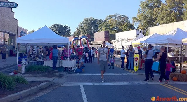 Visitors walking among vendor tents during Taste of Acworth in downtown Acworth, Georgia.