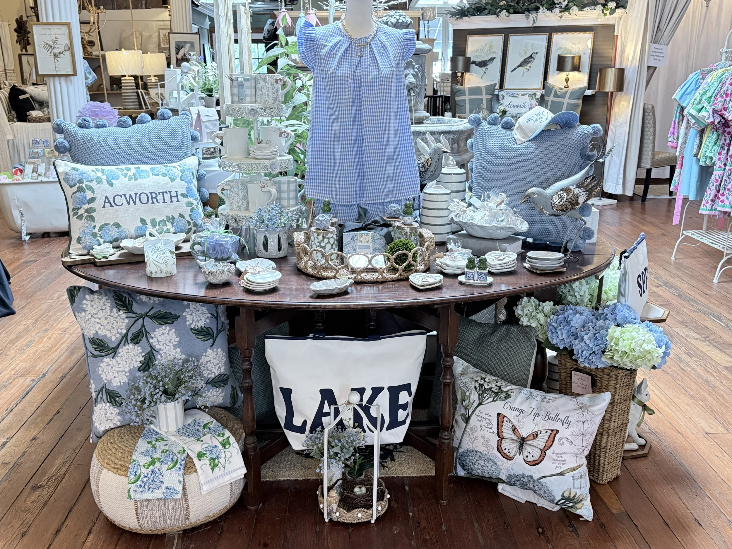 Lake-inspired home décor and accessories displayed inside Wild Blossoms Boutique in Downtown Acworth, featuring decorative pillows, entertaining pieces, gifts, and seasonal summer accents.