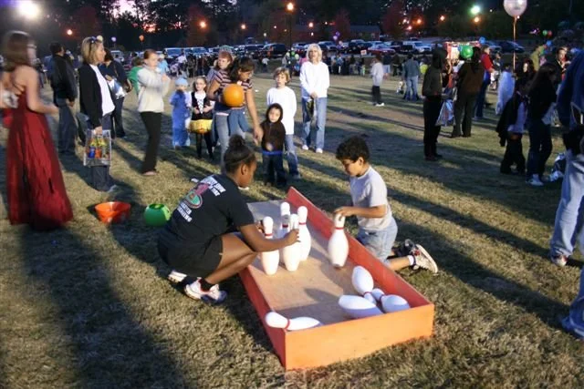 Families and children enjoying Halloween games and activities at an Acworth Halloween JamBOOree event.