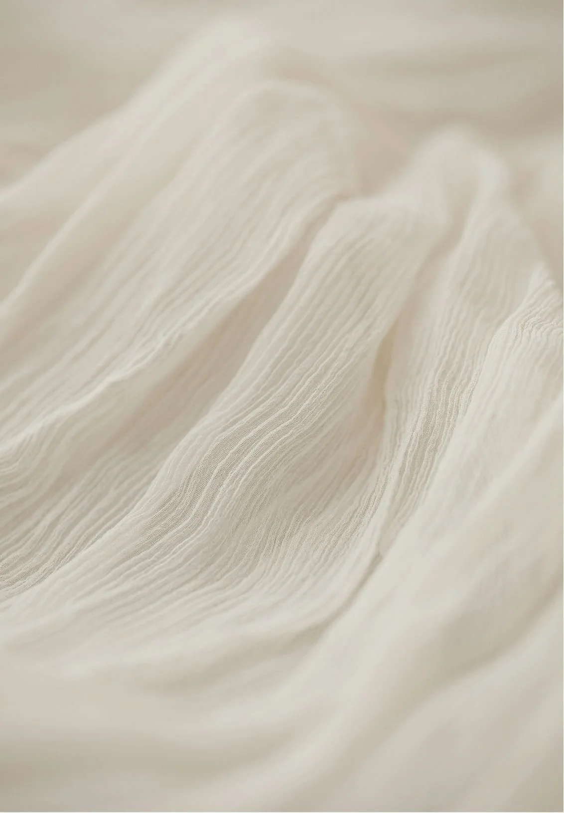 Close-up of white, textured fabric with soft, flowing folds.