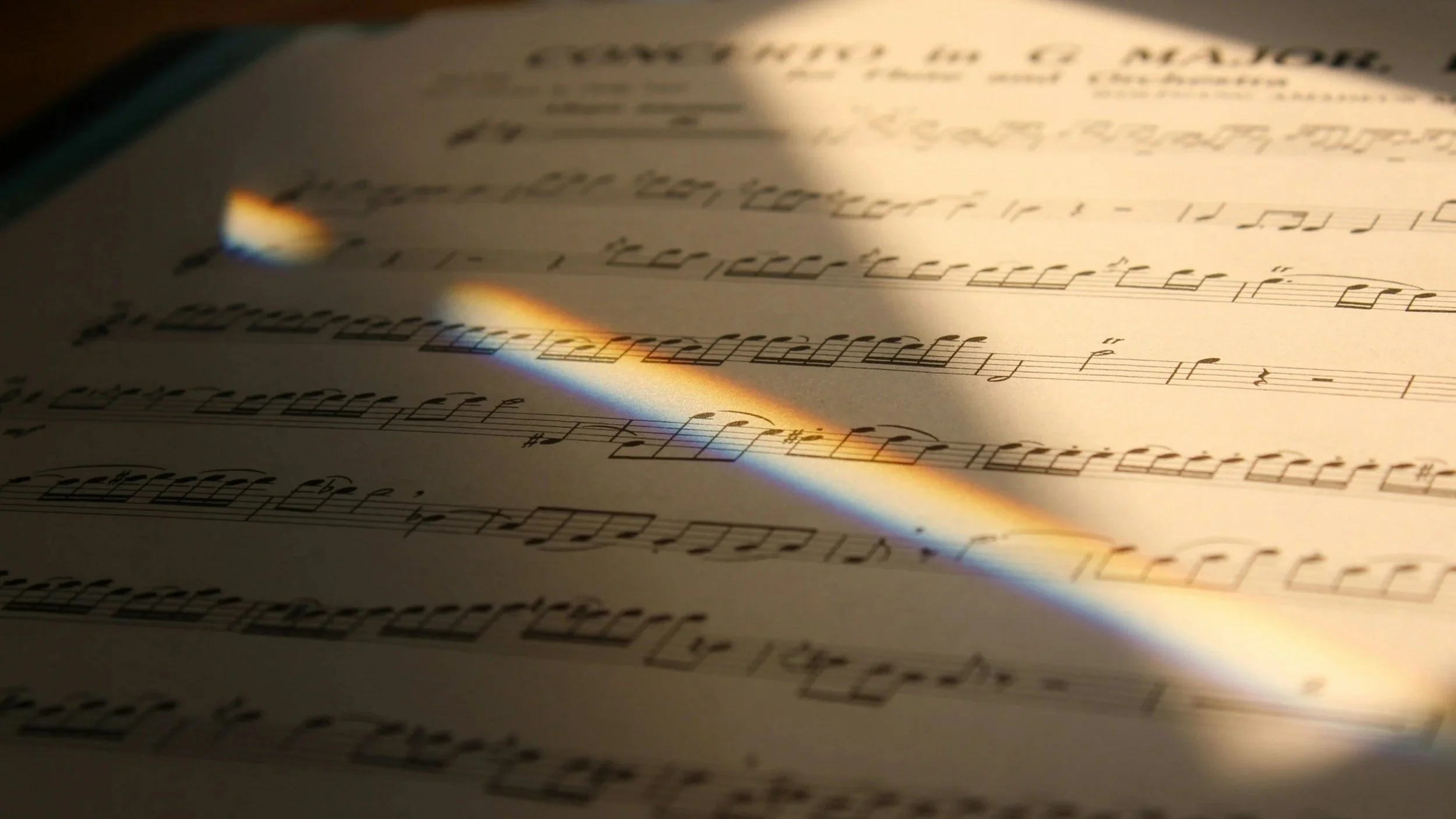 Stock photo of sheet music with a prism ray across it.