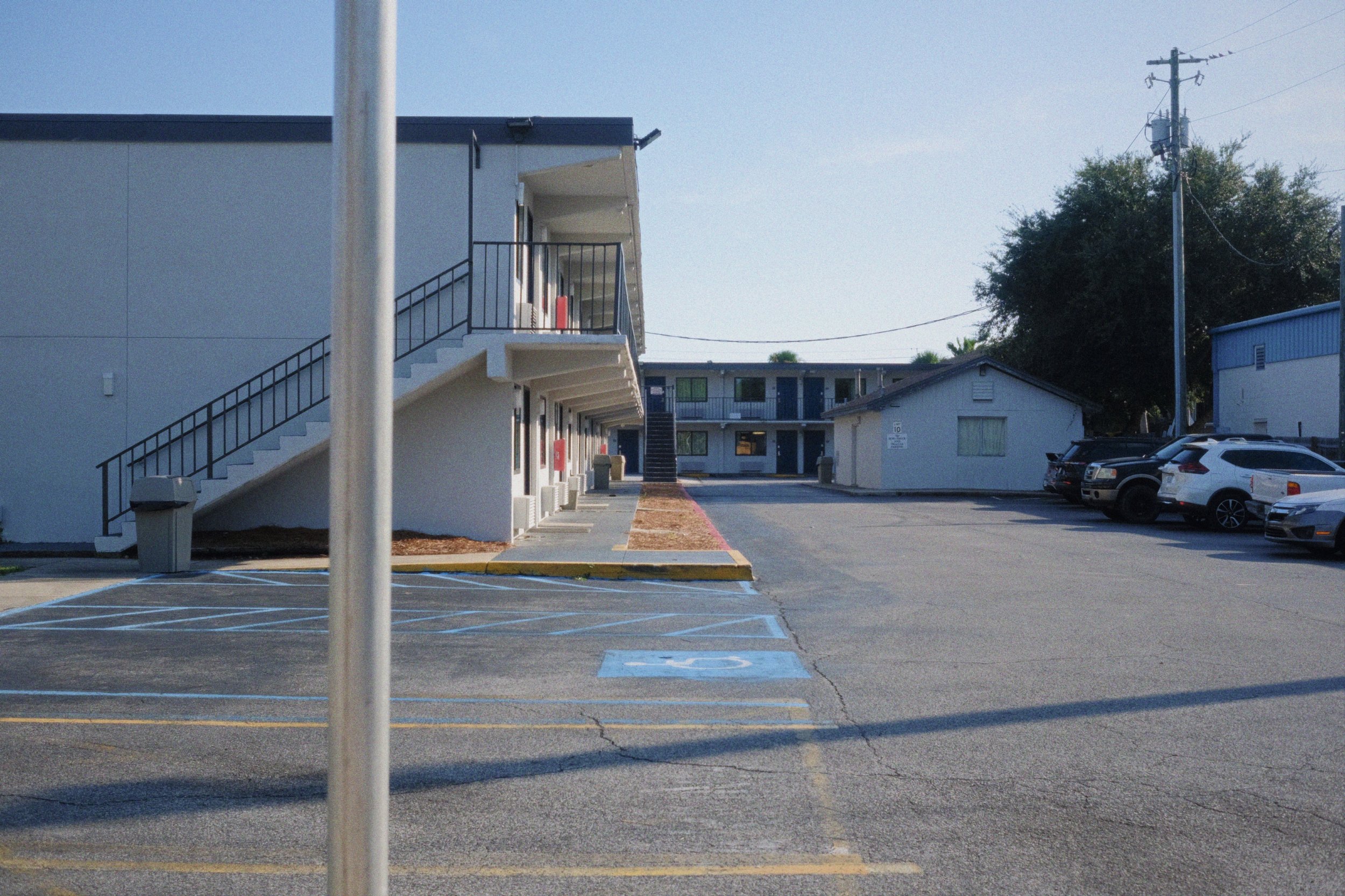 Apartment complex with parking lot and handicap designated parking spaces.