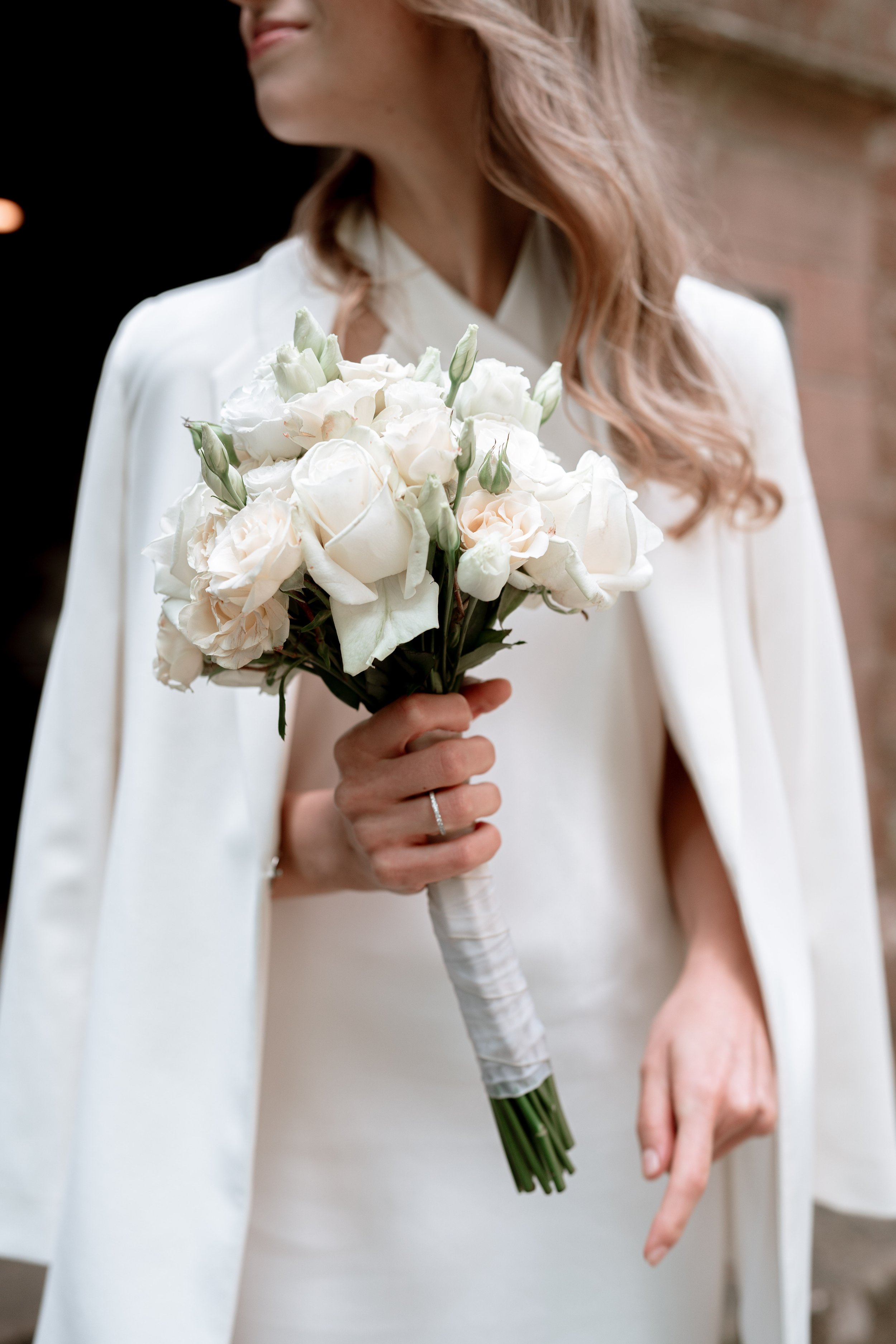 A woman in a white dress holding a bouquet of white flowers