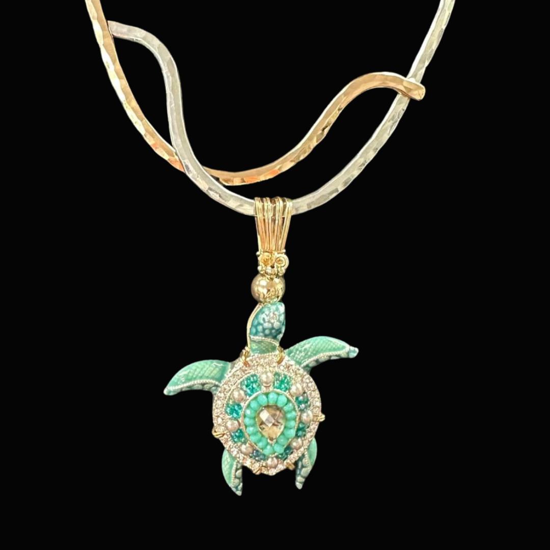 A pendant necklace with a turtle design, featuring turquoise and diamond accents, hanging from a twisted metallic chain against a black background.