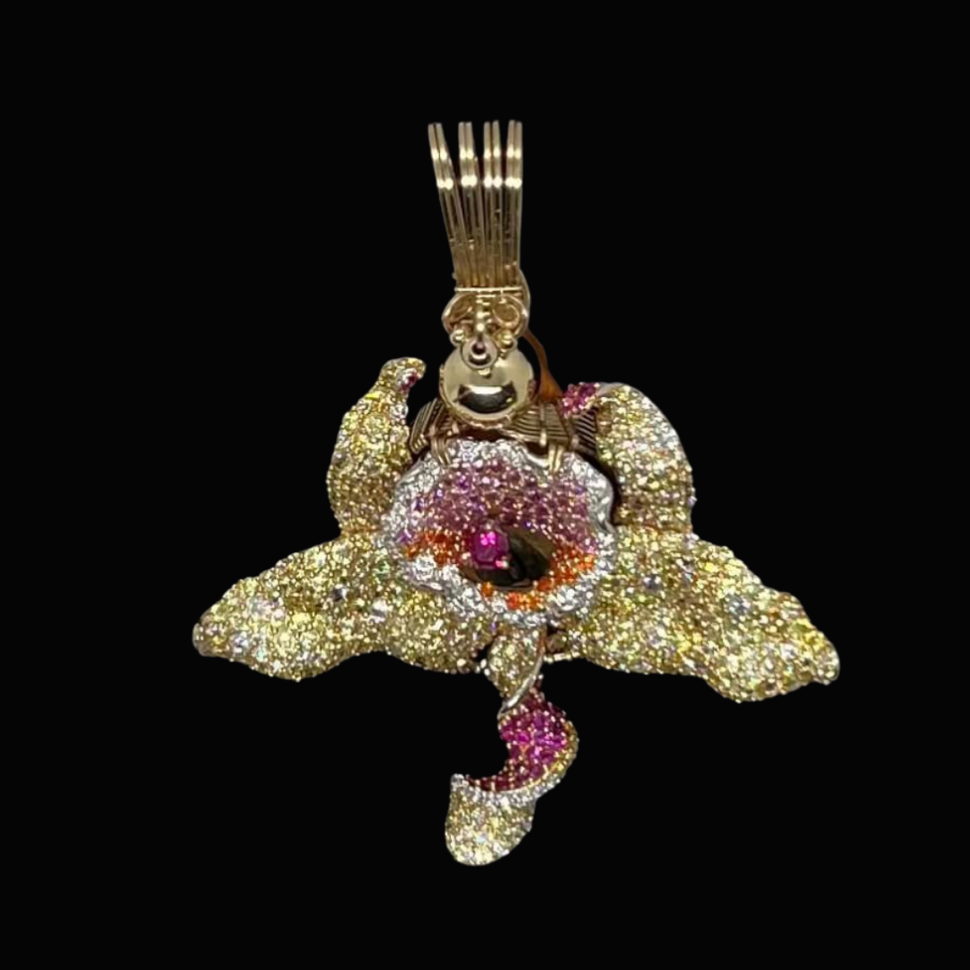 Gold and diamond orchid-shaped pendant with pink and orange gemstones on a black background.
