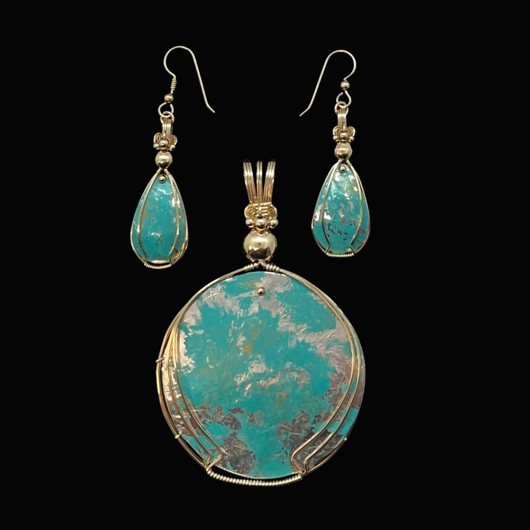 Silver jewelry set with turquoise stones, including a large oval pendant and matching earrings, displayed against a black background.