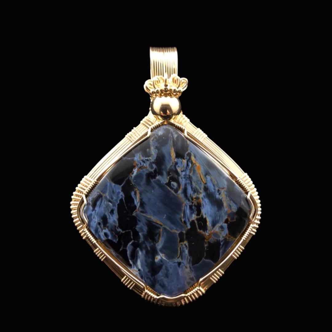 Gold pendant with a large, polished black and blue marbled stone on a black background.