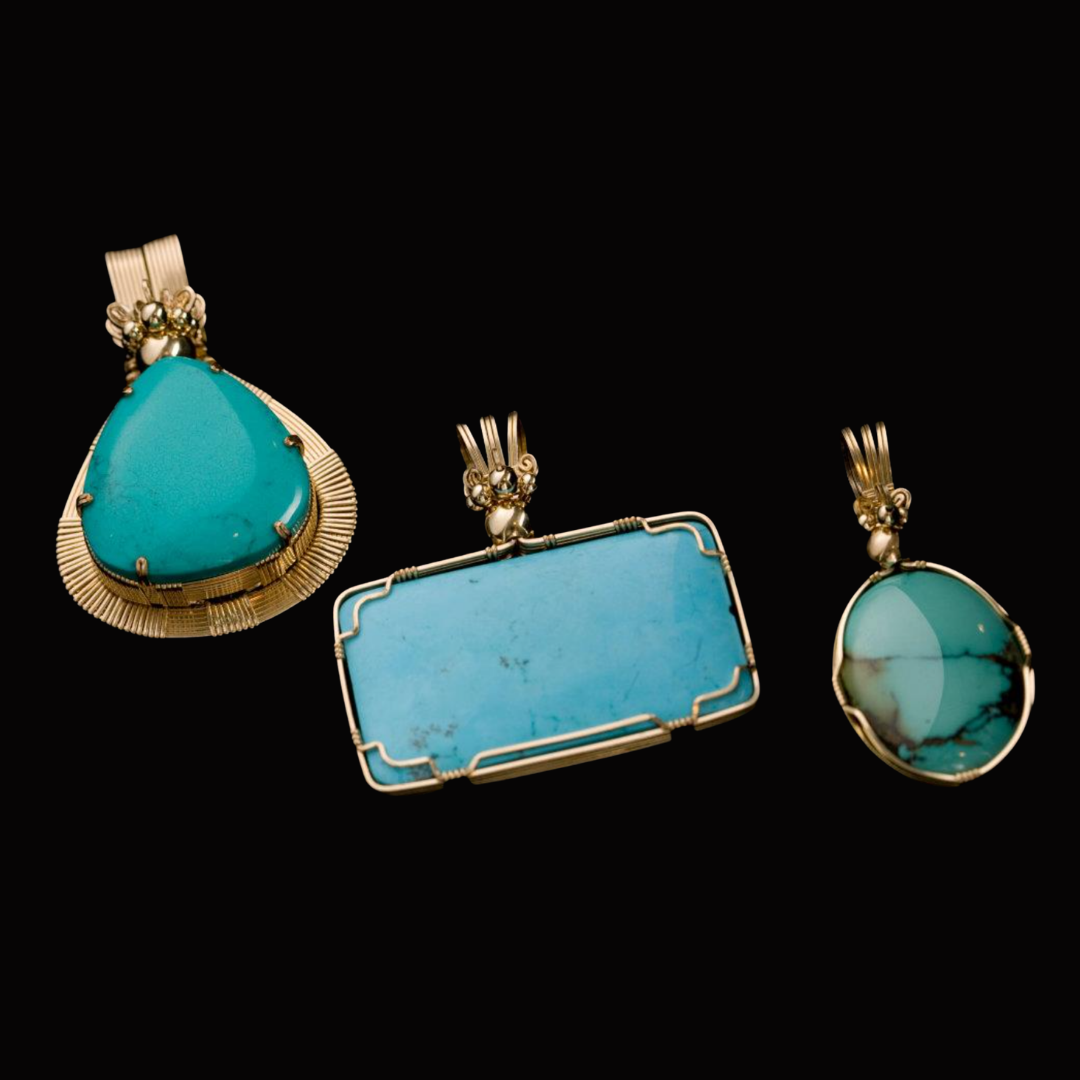 Three turquoise gemstone pendants with gold settings on a black background.