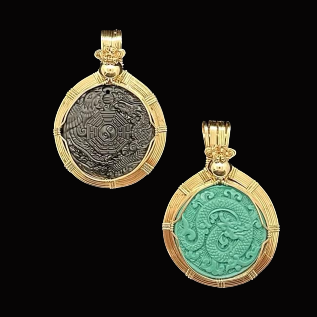 Two gold pendants with dragon and yin-yang designs, one with a dark gray background and the other with a turquoise background, set against a black background.