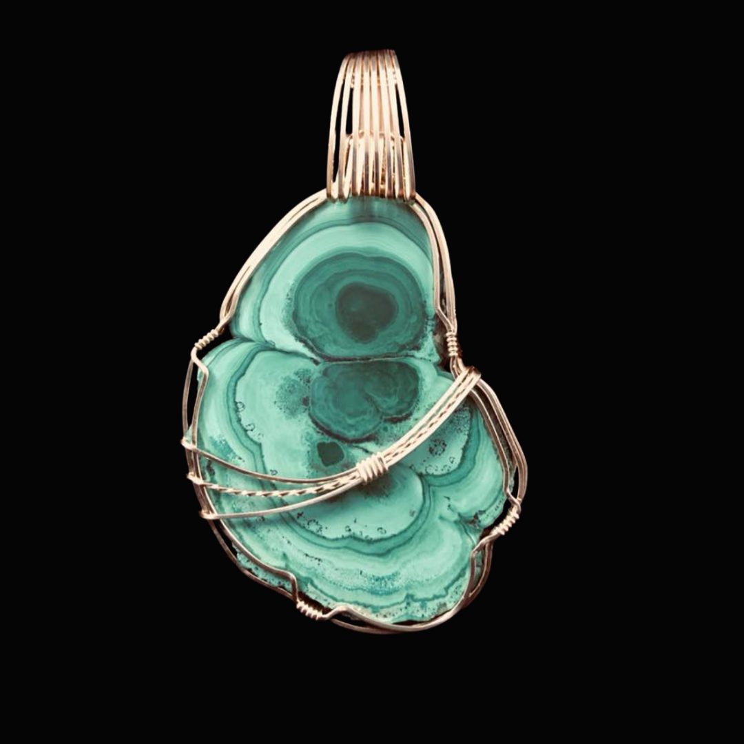 A pendant featuring a large, polished turquoise stone wrapped in silver wire, set against a black background.
