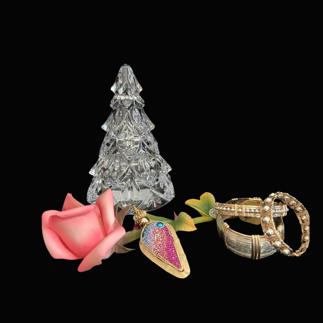 Decorative glass Christmas tree, pink rose, beaded leaf pendant, two gold rings with pearls, on a black background.