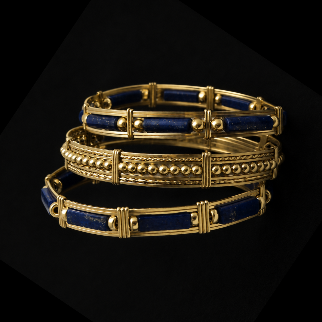 Three gold bracelets with blue inlay and decorative beads displayed on a black background.