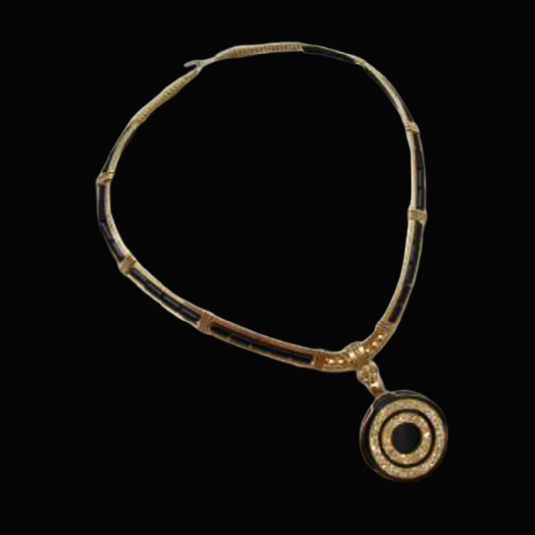 Gold necklace with a circular, concentric design pendant against a black background.