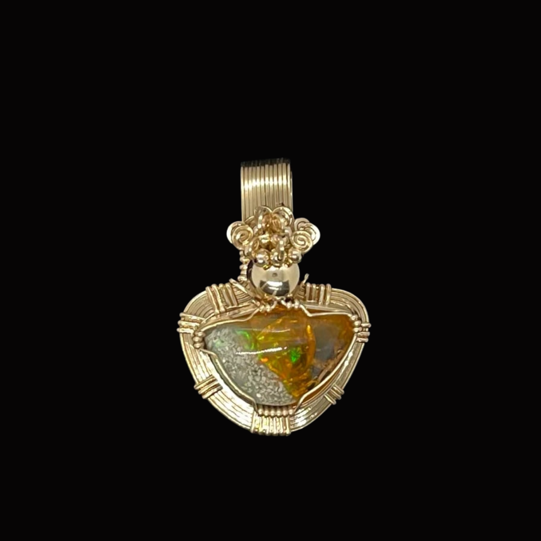 Gold pendant with a large, irregular amber stone and intricate gold detailing on a black background.