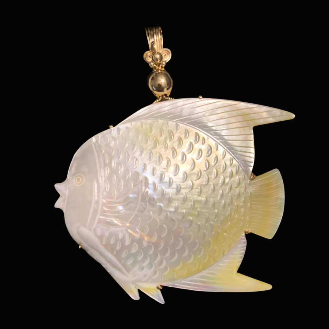 Pendant featuring a carved fish made of iridescent shell with gold accents and a gold bail