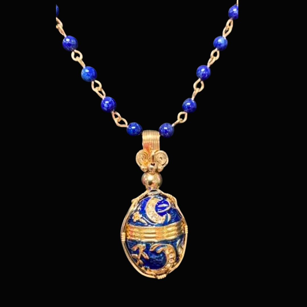 Gold and blue beaded necklace with a decorative oval pendant against a black background.