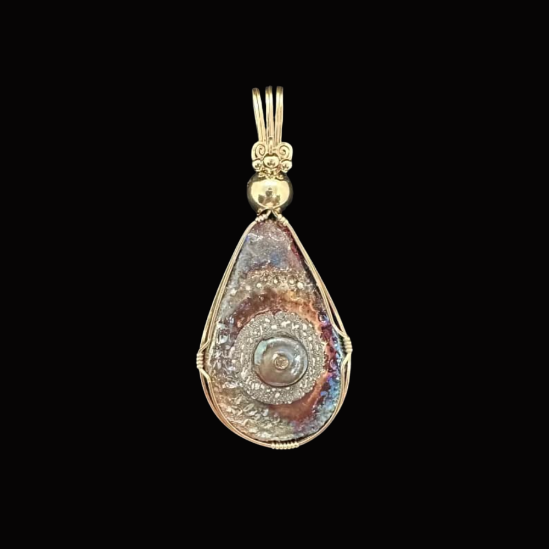 Silver pendant with a colorful, spiral-patterned shell encased in a wire frame, on a black background.