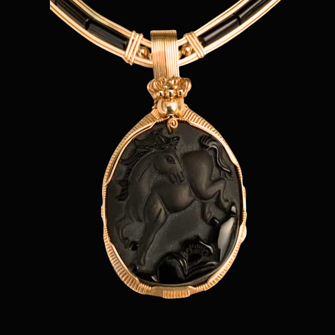 Gold necklace with a large black cameo pendant depicting a horse.