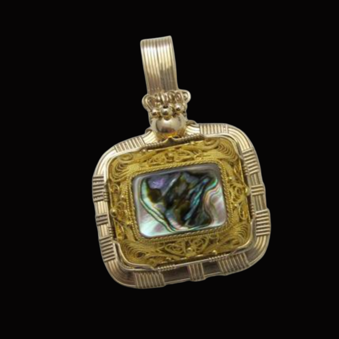 Gold ornate pendant with a rectangular black and iridescent star-shaped stone, set against a black background.
