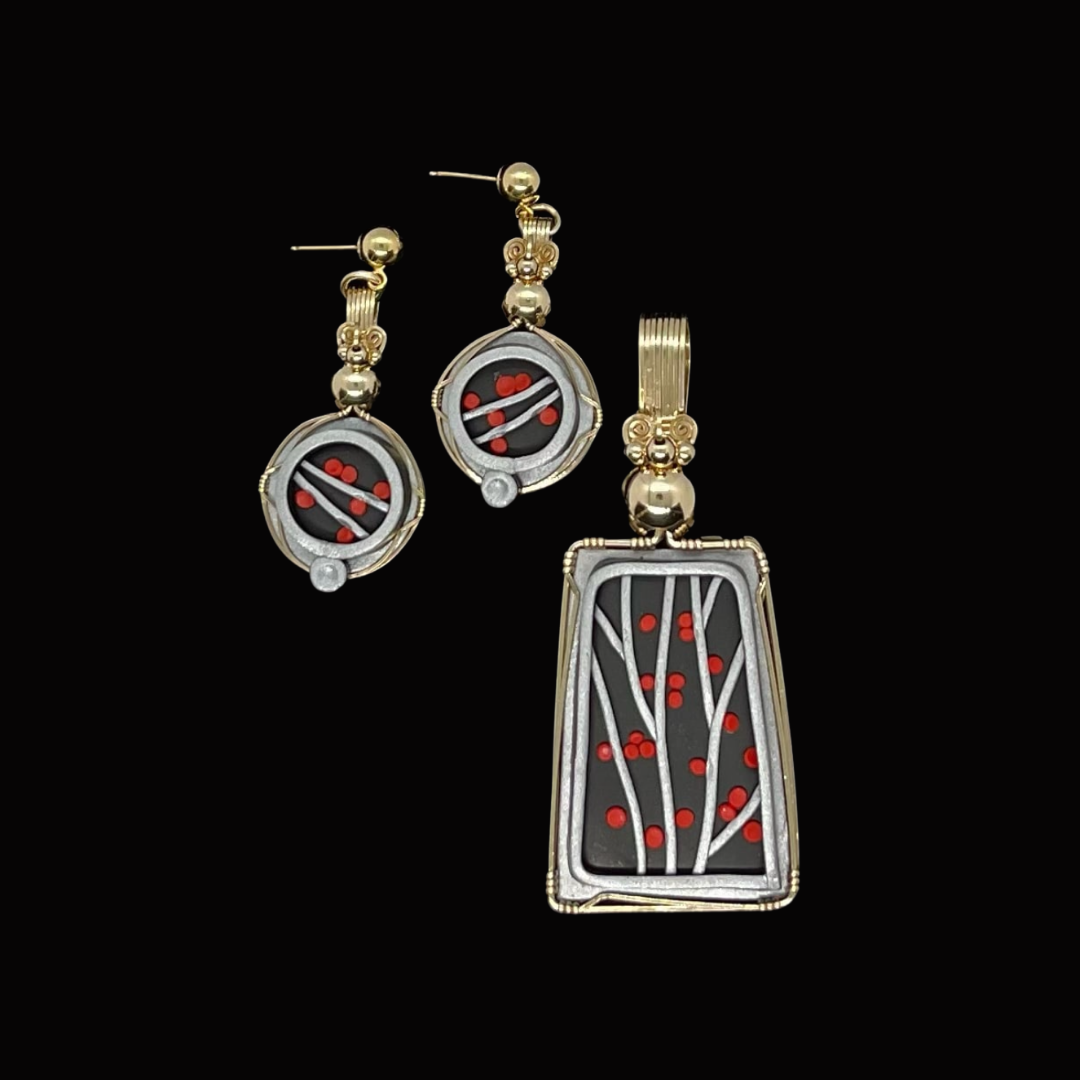 Set of gold and silver linked jewelry with black and red decorative elements, including a pair of earrings and a pendant.