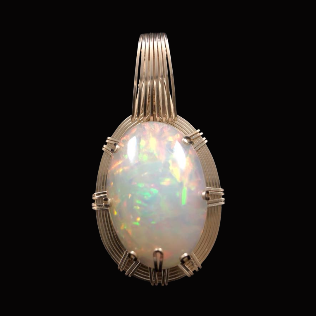 Ring with an oval-shaped opal gemstone set in a gold band with multiple prongs and decorative gold accents.