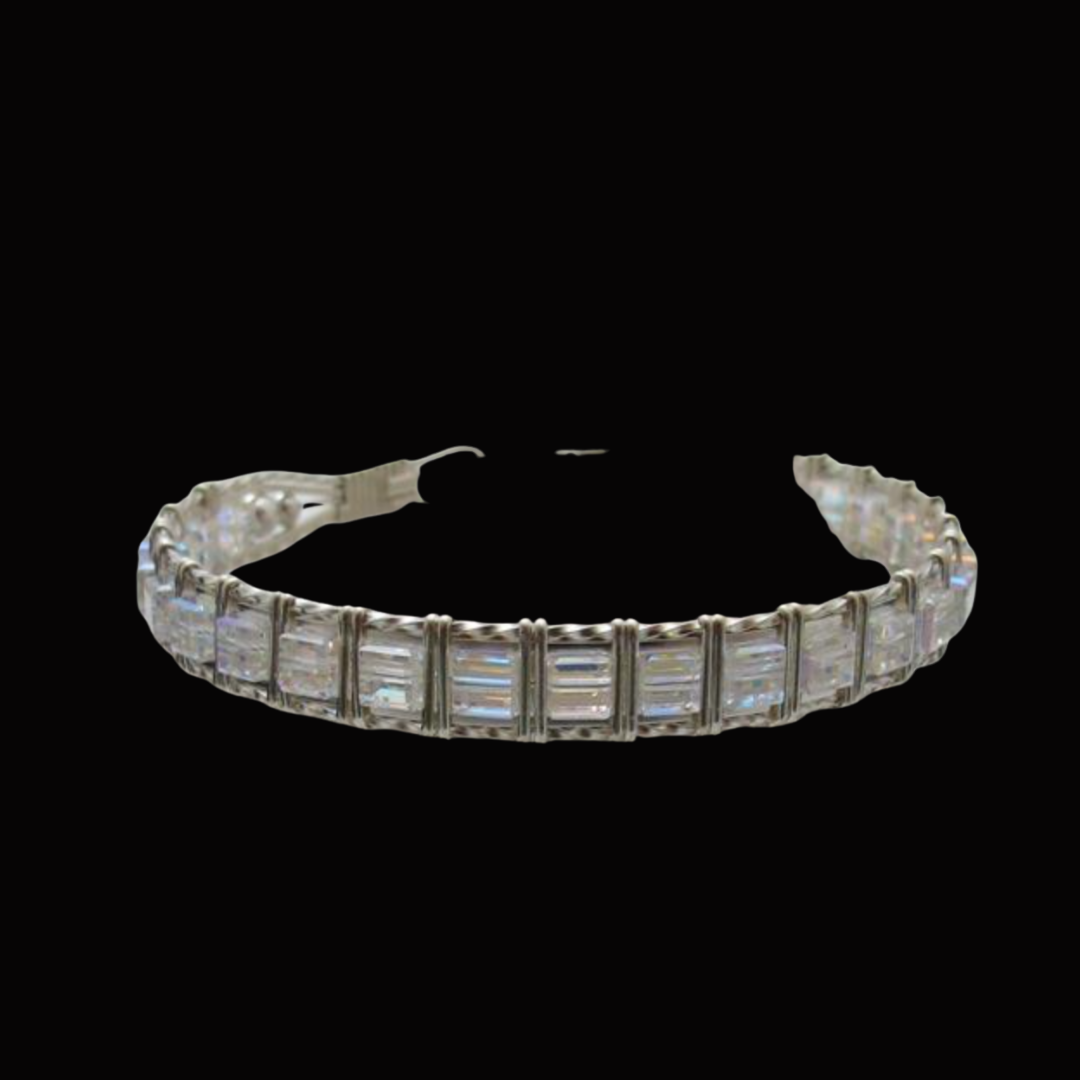 Diamond tennis bracelet with rectangular cut stones on a black background.