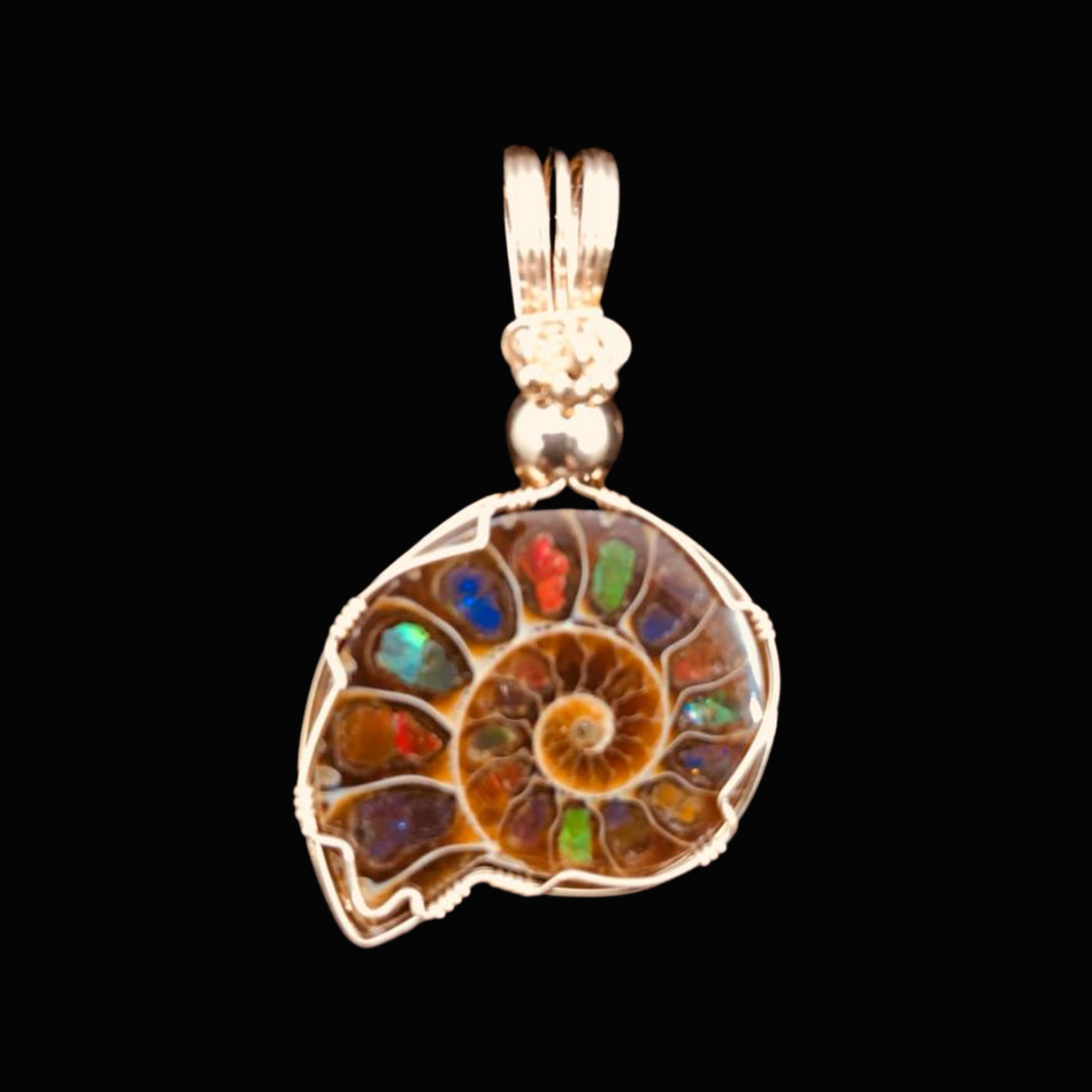 Pendant necklace with a spiral shell design featuring colorful inlay stones and a silver bail, displayed against a black background.