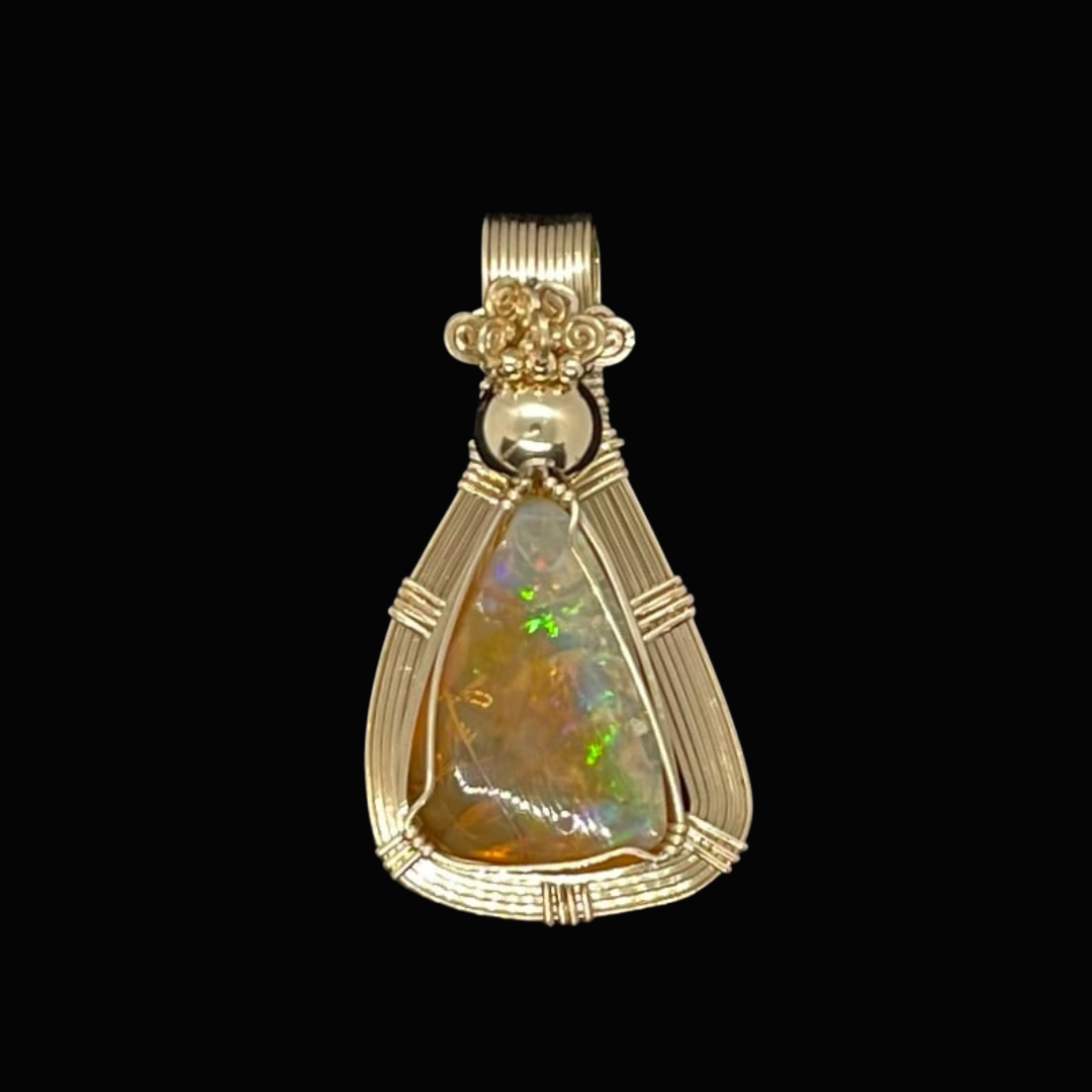 Gold pendant with a large iridescent opal gemstone set in a decorative gold frame on a black background.