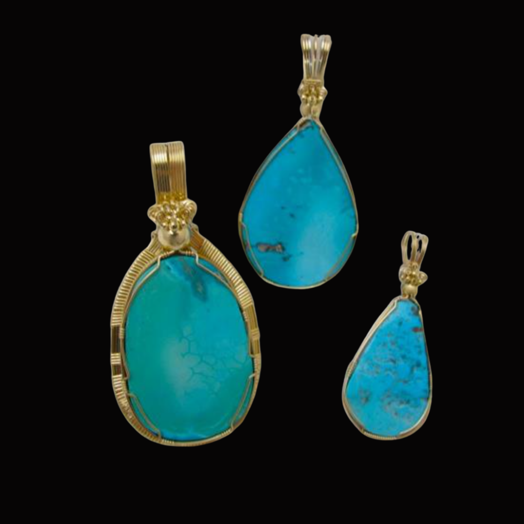 Set of three turquoise gemstone jewelry pendants with gold settings, displayed against a black background.