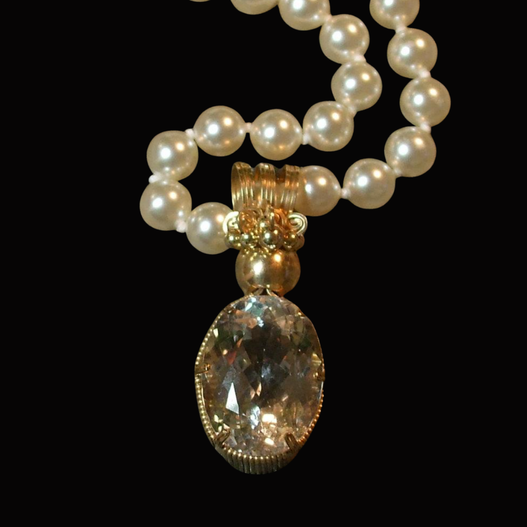 Pearl necklace with a large, oval-shaped gemstone pendant against a black background.