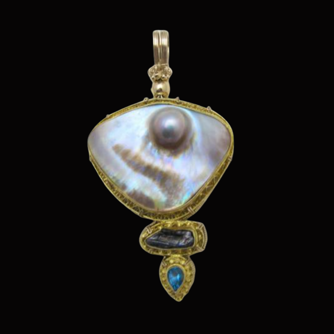Gold pendant featuring a large pearl embedded in a shell-shaped setting with a blue gemstone and a black gemstone below it, on a black background.