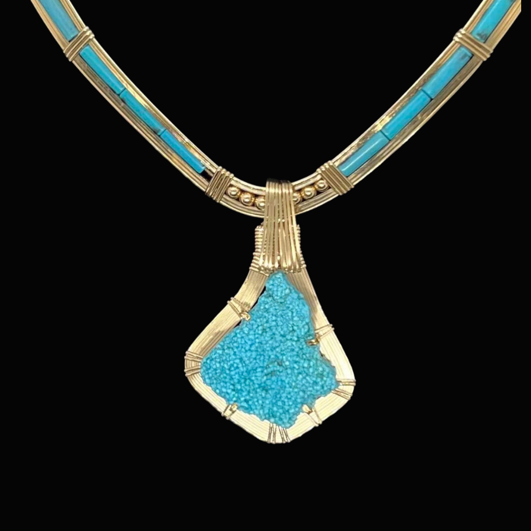 Gold necklace with turquoise stones and a large turquoise pendant.