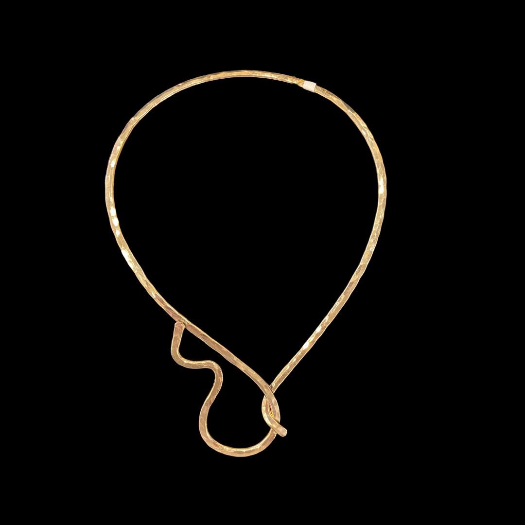 A gold Neckwire necklace on a black background