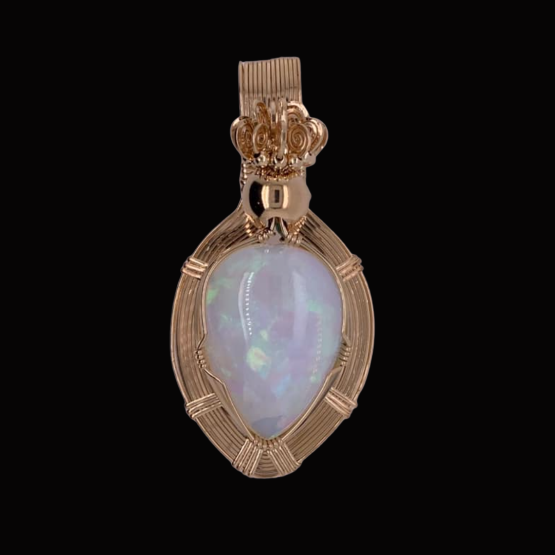 Gold pendant with an iridescent opal stone set in an intricate gold wire design, hanging against a black background.