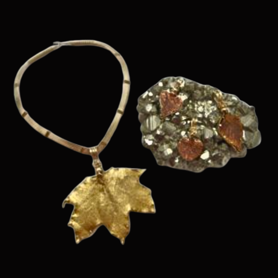 A necklace with a maple leaf pendant and a ring with a cluster of small, shiny stones and embedded heart-shaped ornaments.