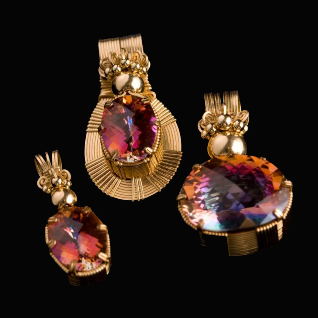 Gold jewelry set with large, multicolored gemstones, including earrings and a pendant, displayed against a black background.