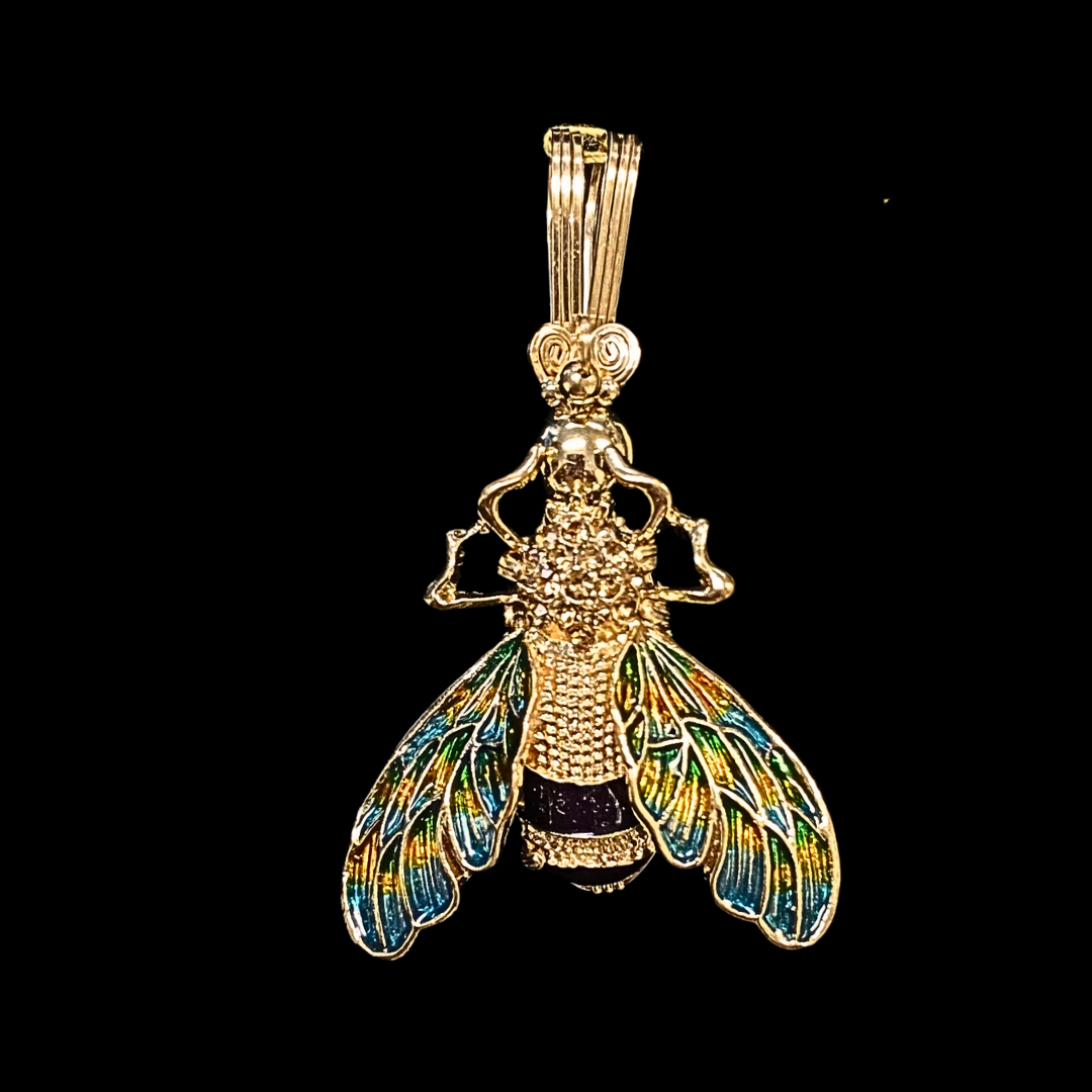 Gold pendant shaped like a bee with colorful, iridescent wings against a black background.