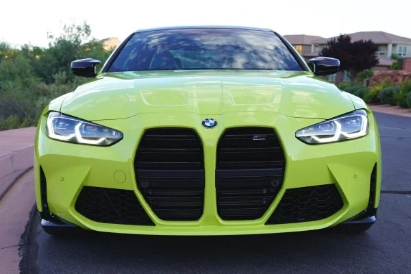 a sporty bright yellow BMW faces the camera