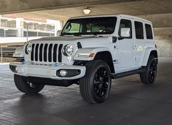 A shiny white jeep sits inside a parking garage