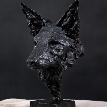 A black sculpture of a wolf's head on a black base.